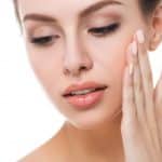 woman touching her face