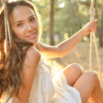 woman-is-swinging-on-a-swing-in-summer-pine-forest.